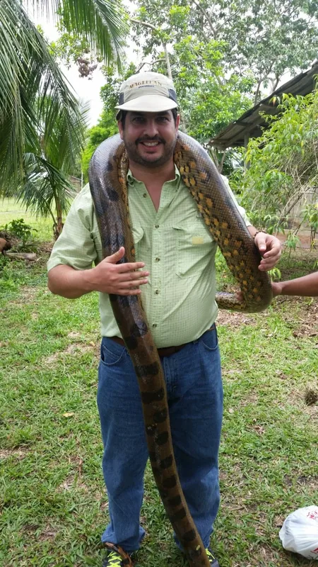 Miguel holding a snake during a tropical wildlife encounter