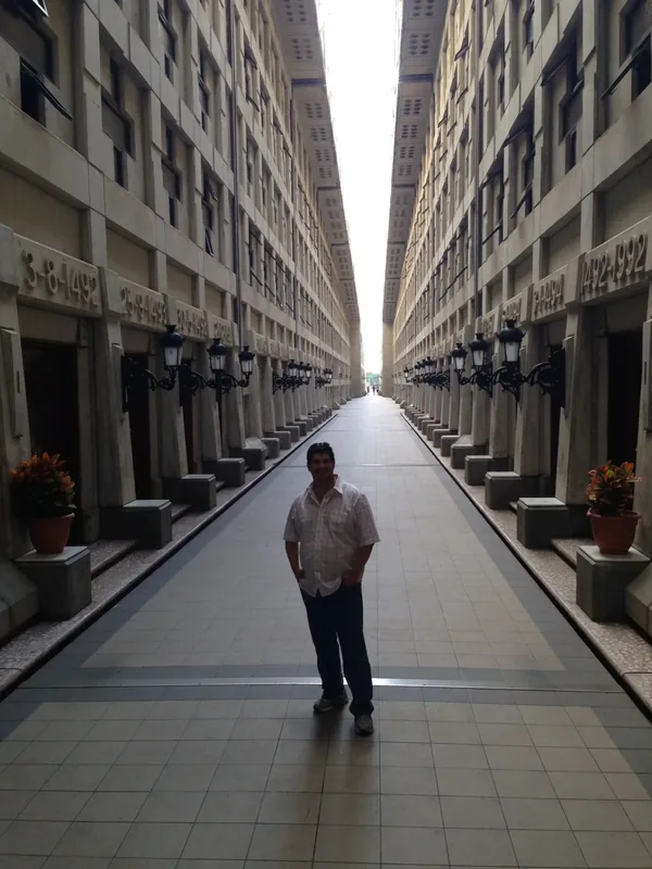 Miguel walking through a historic city passage lined with buildings