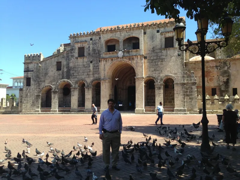 Miguel standing in a plaza before a historic colonial church